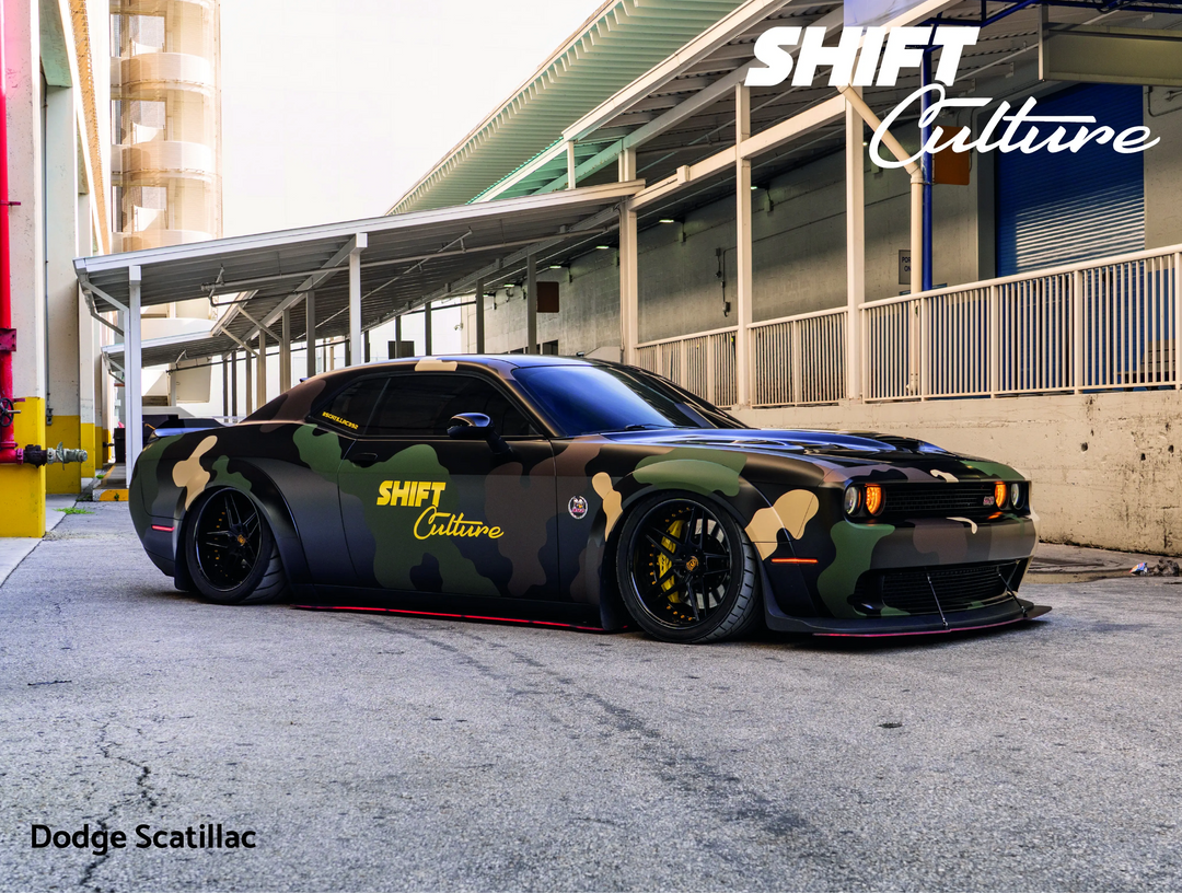 Camouflage-patterned Scatilac parked under a building with 'Shift Culture' branding.